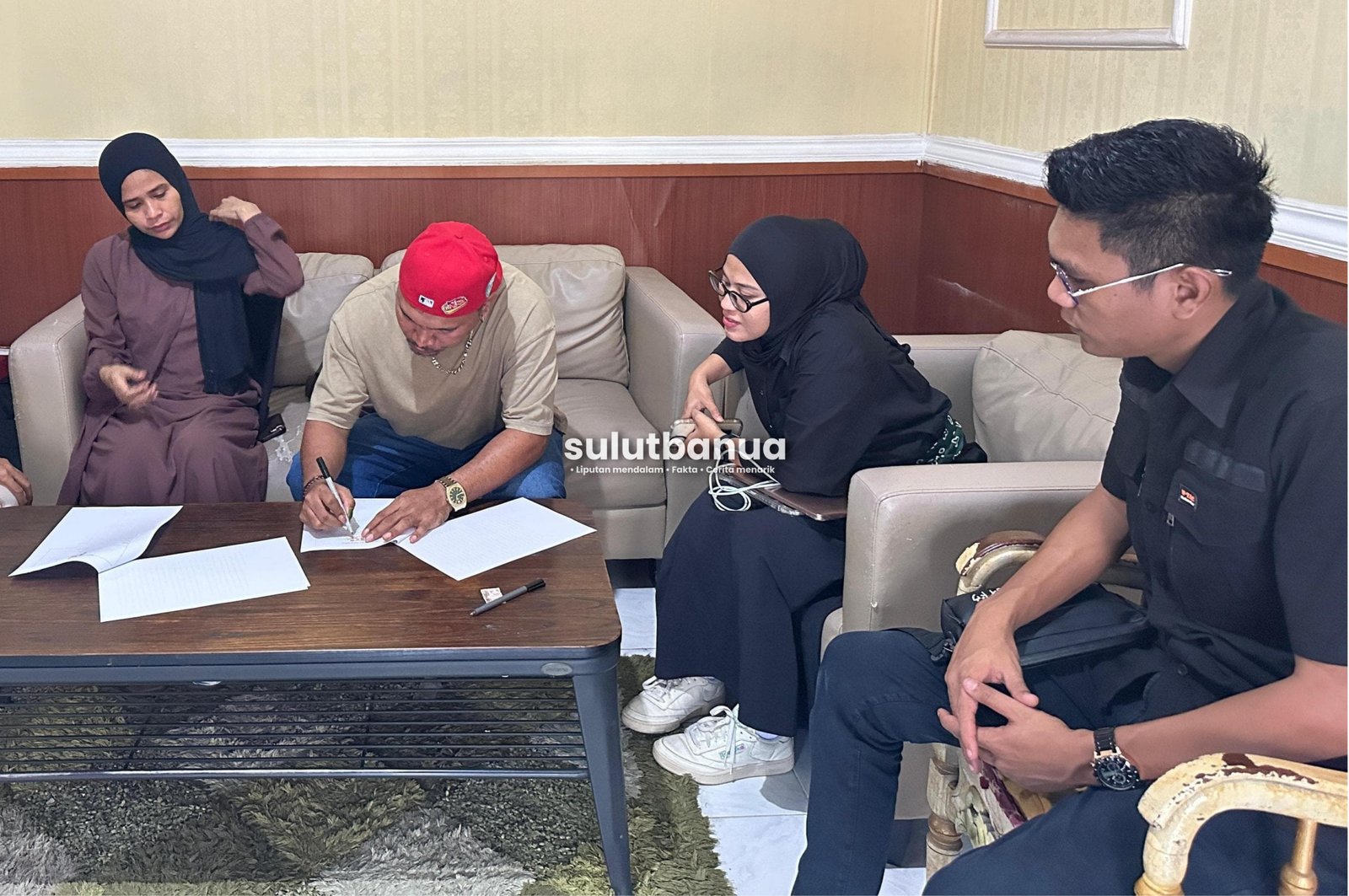 Momen penandatanganan dokumen kesepakatan damai antara para pihak di dalam sebuah ruangan, yang menandai dicabutnya pengaduan terhadap Wizz Baker.